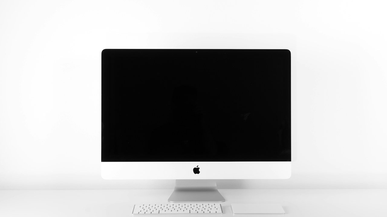 Clean wooden desk with laptop and organized workflow accessories.