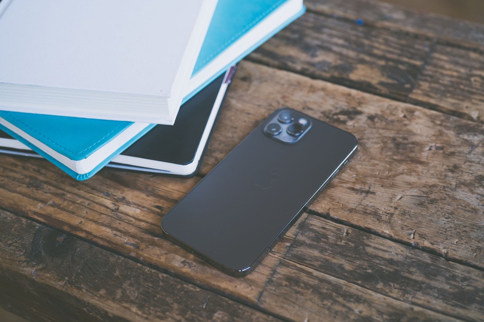Smartphone tapping a small adhesive NFC tag attached to a modern wooden desk.