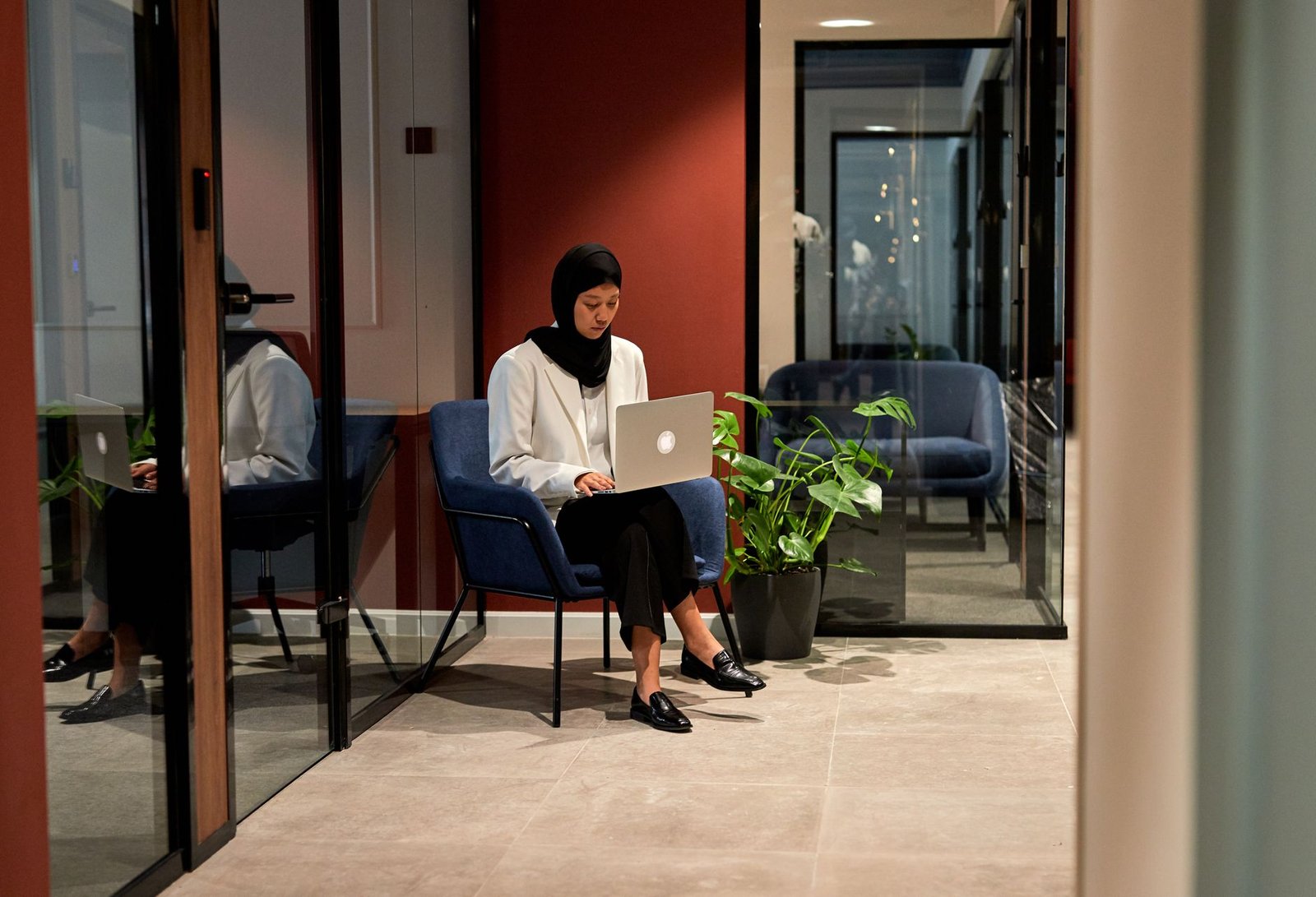 Focused professional working on a laptop in a bright, contemporary workspace.