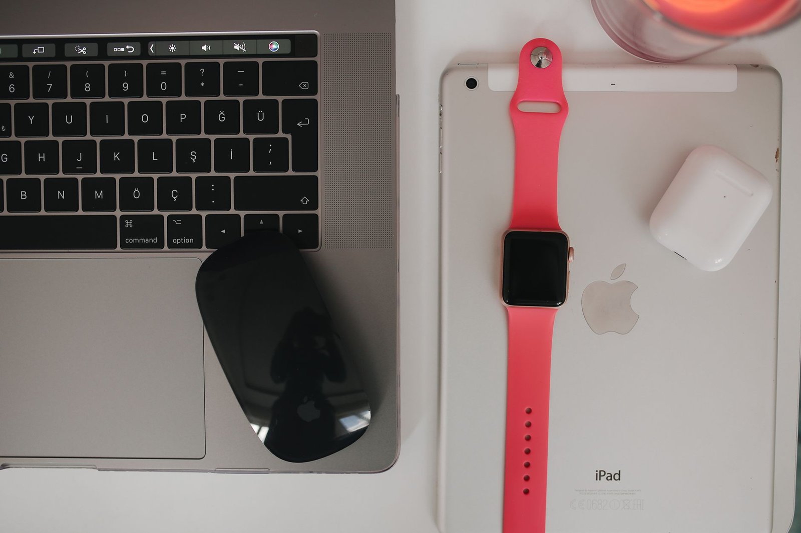 A magnetic charging puck connected to a rugged titanium smartwatch on slate.