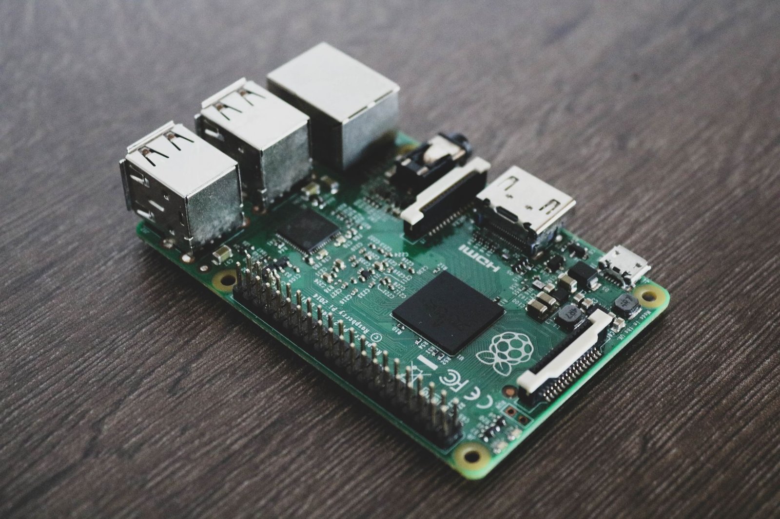 A compact green Raspberry Pi circuit board connected to home network cables.