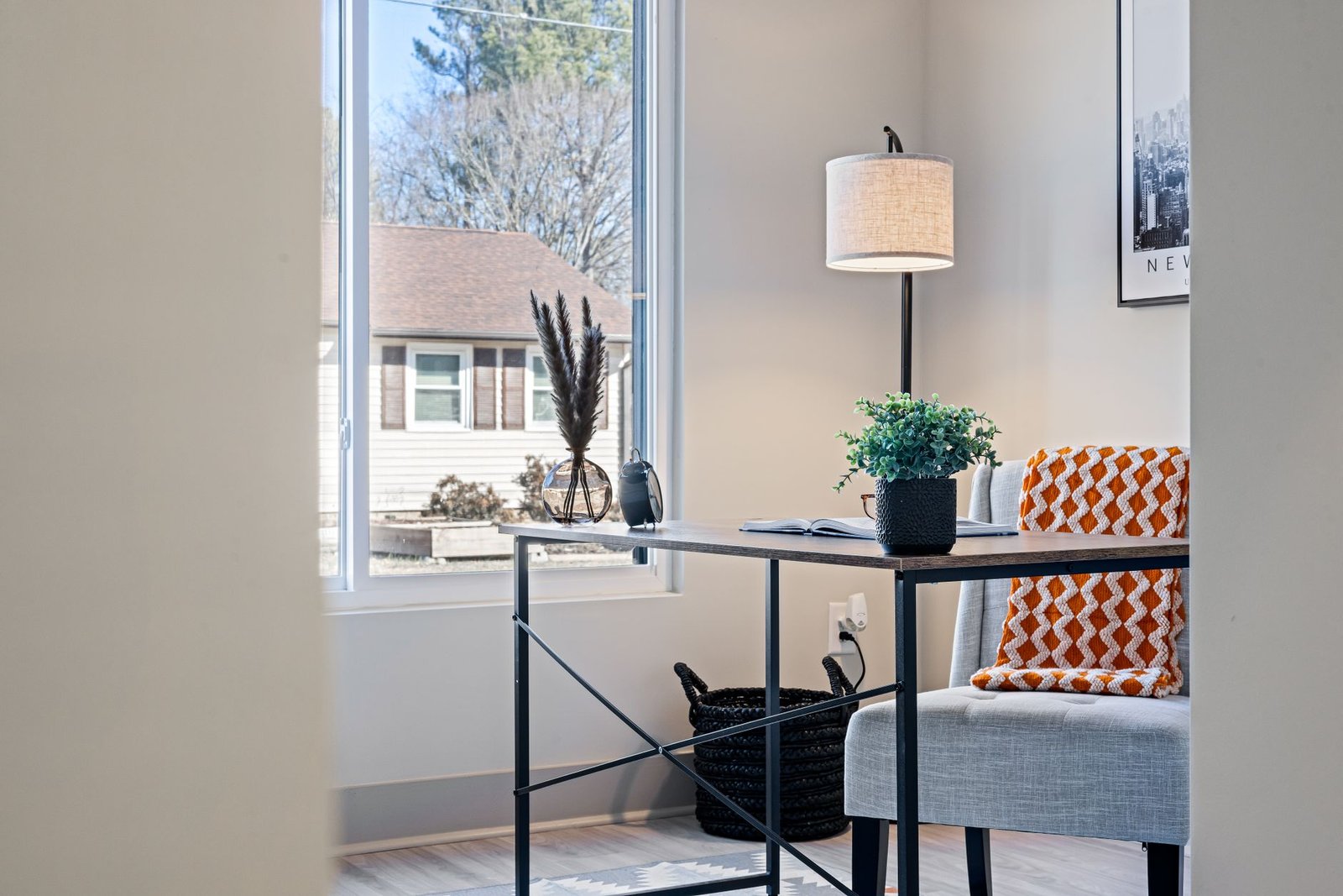 A clean, minimalist home office desk with organized equipment and natural light.
