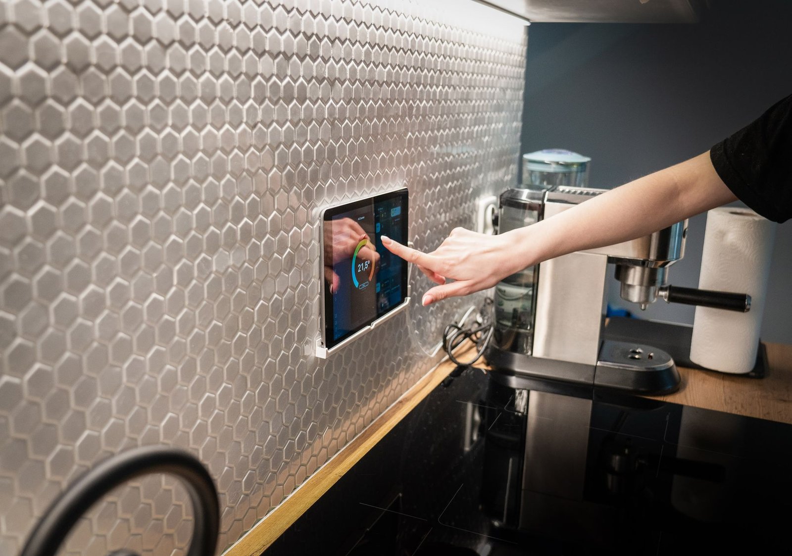 Clean modern smart home control tablet mounted on a wooden wall.