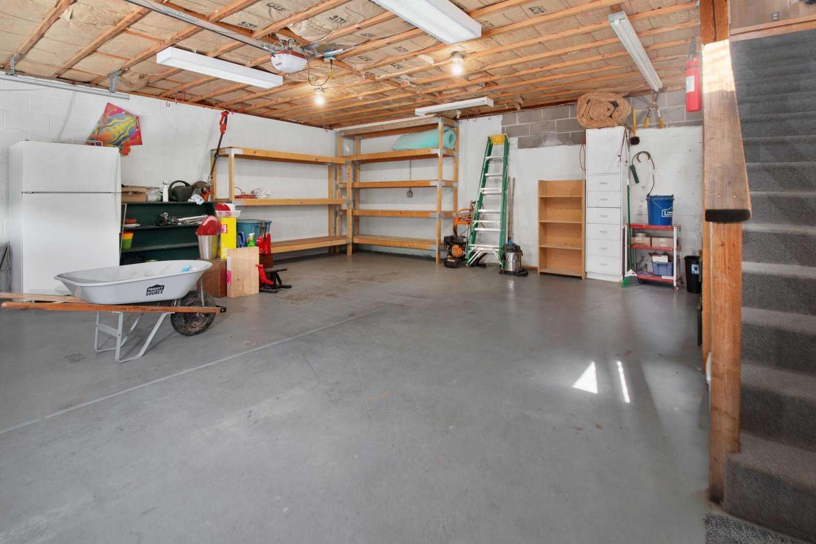 Sturdy metal shelving units neatly holding labeled plastic storage bins in a garage.