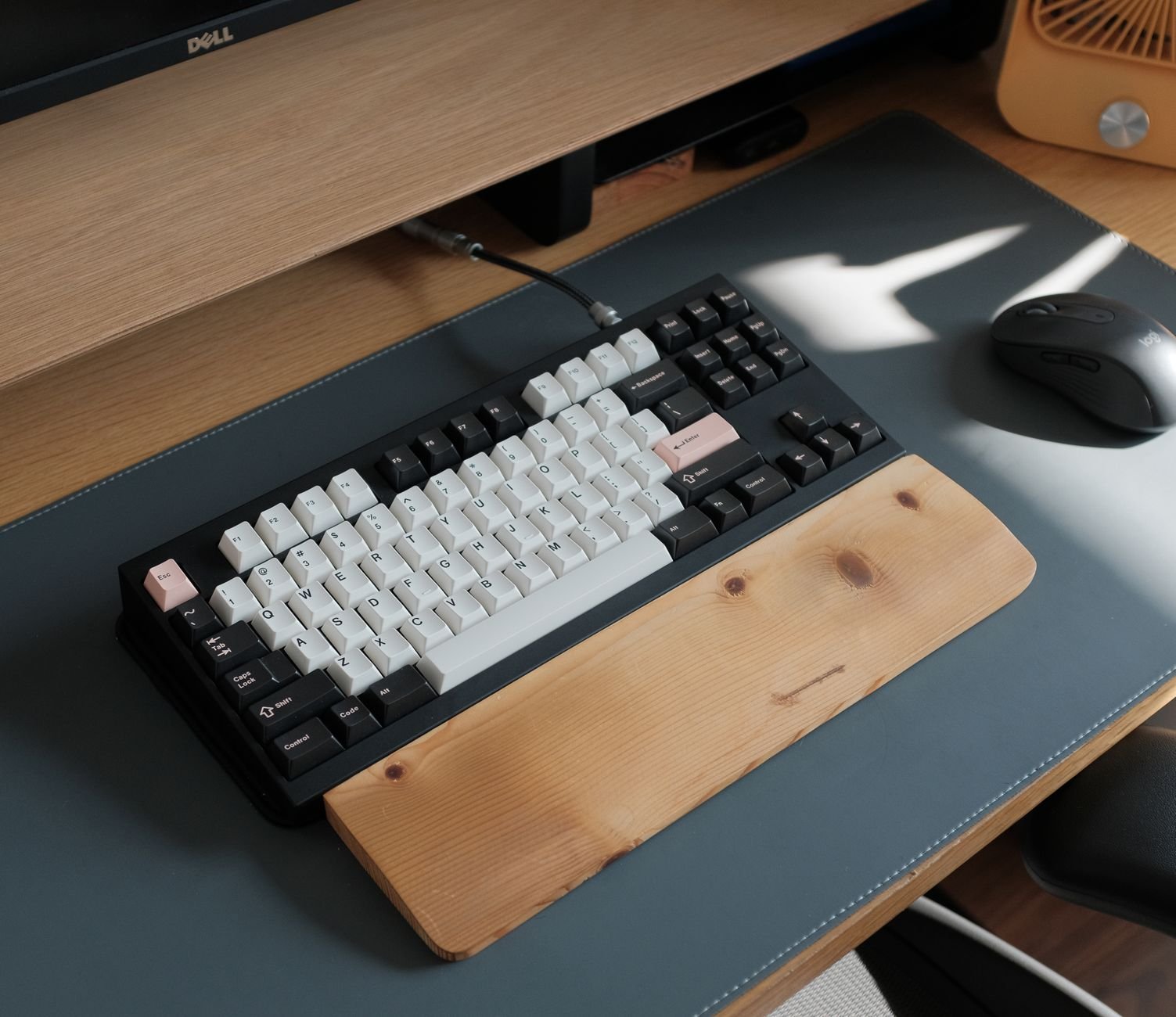 An organized modern workspace with multiple screens and a wireless keyboard.