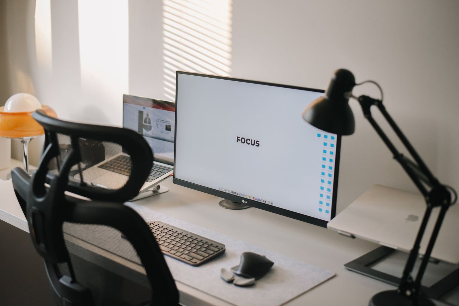 Minimalist clean desk setup featuring a single monitor and external keyboard.
