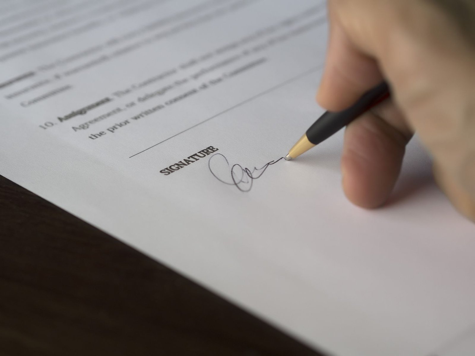 A modern digital document signing screen displaying contract terms and a signature box.