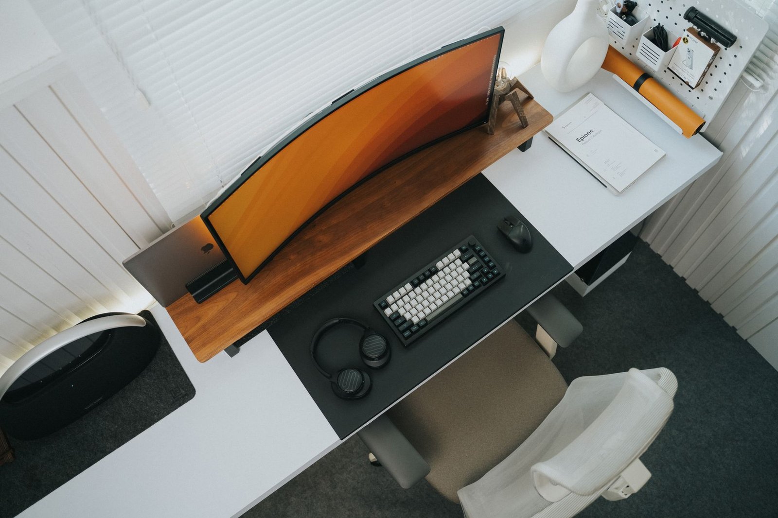 A clean minimalist desk with a single laptop and notebook.