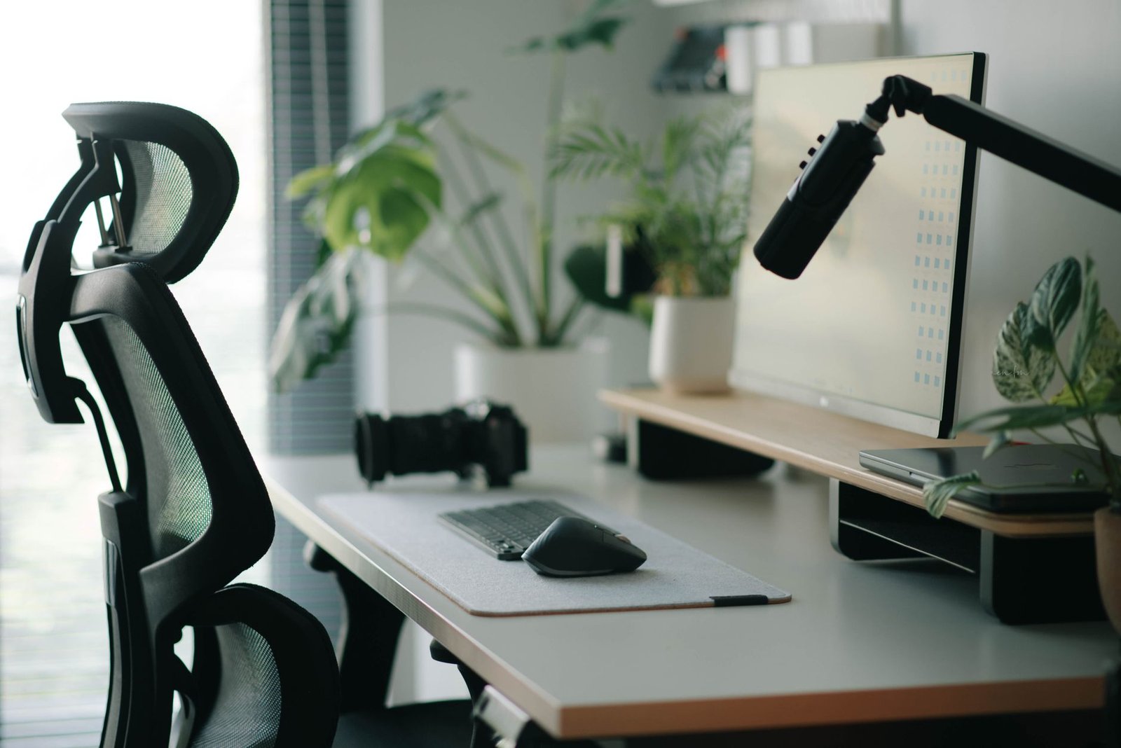 A clean minimalist desk setup with proper laptop elevation and external keyboard.