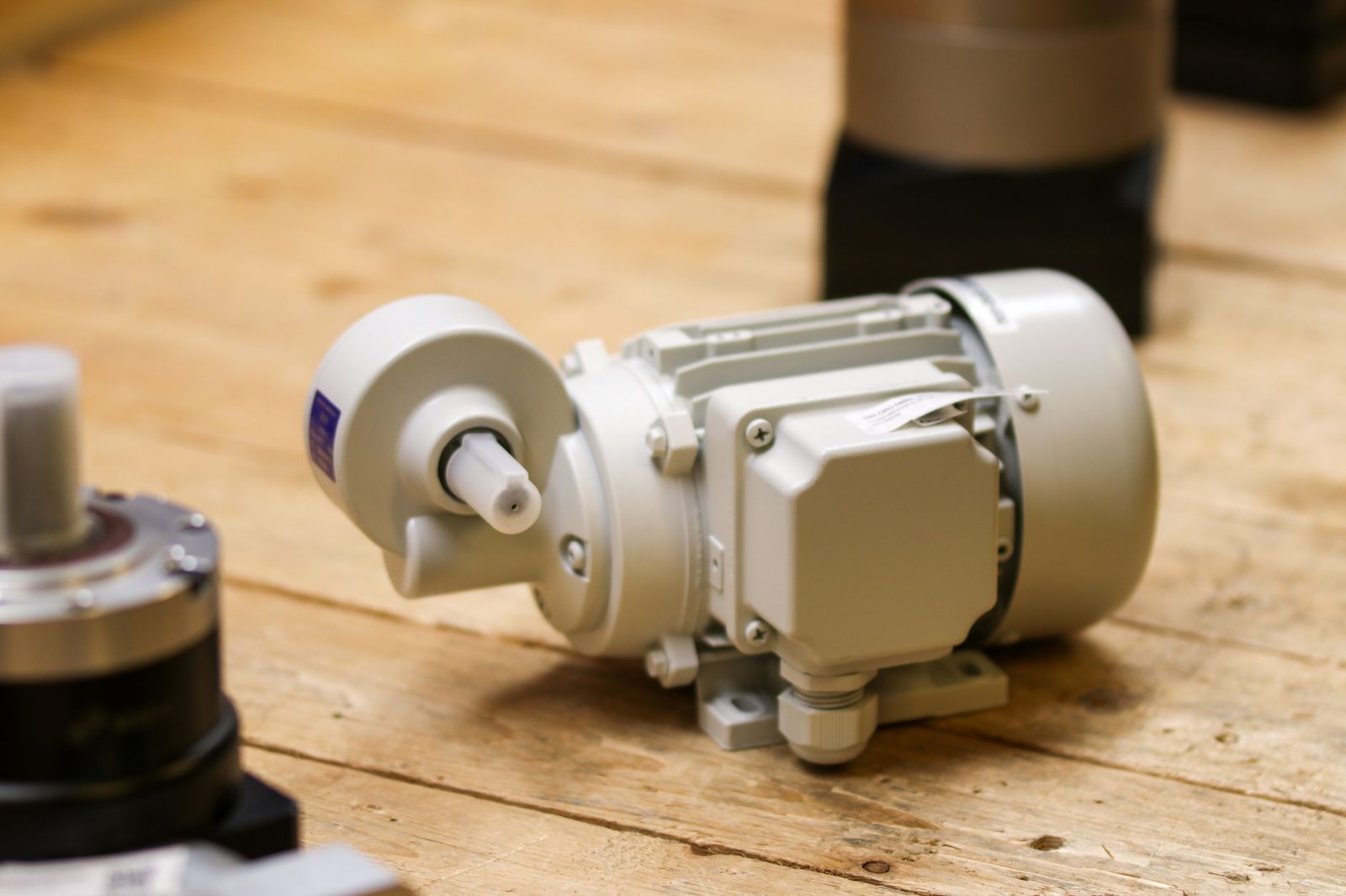 Dual motor leg housing mounted beneath a solid oak desk surface.