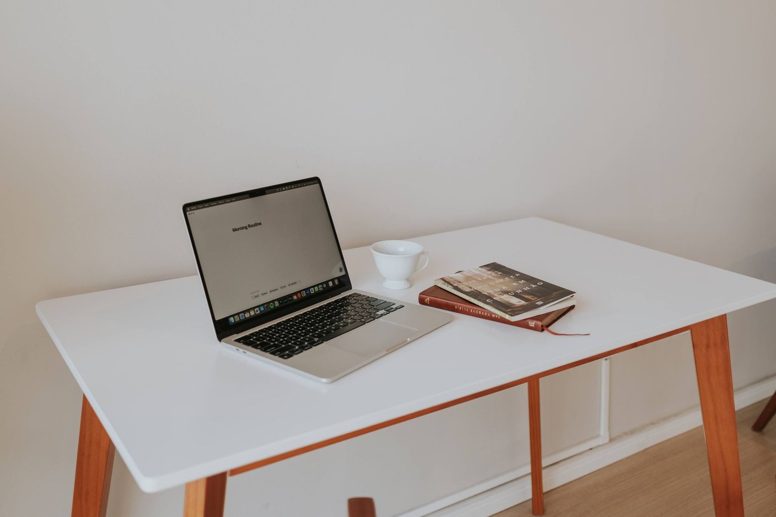 Clean minimalist desk setup featuring a laptop and high-end over-ear headphones ready for work.