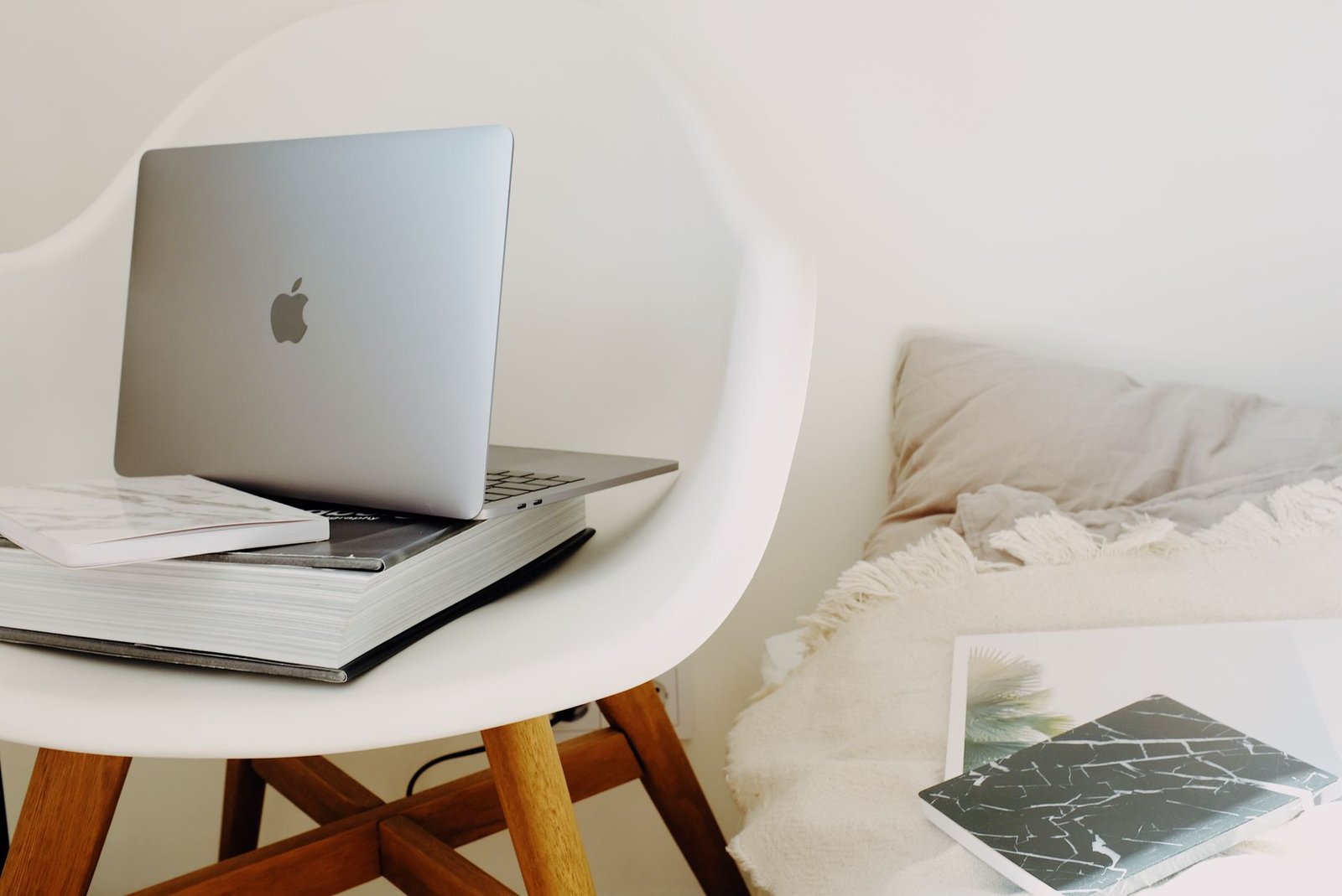 A clean wooden desk setup featuring an open laptop displaying structured project management dashboards.