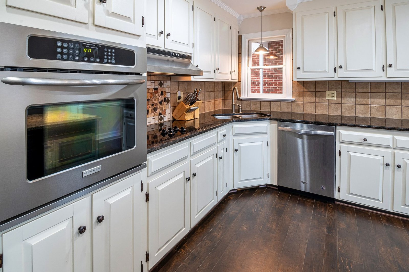 Organized kitchen corner cabinet featuring a rotating lazy susan with spices and jars.