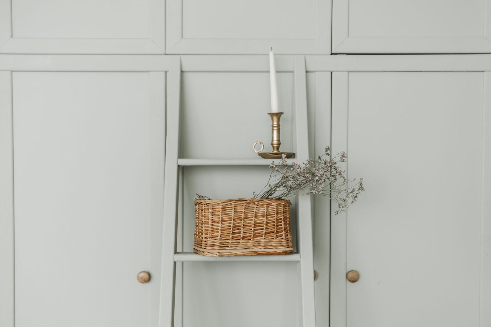 A row of natural woven storage baskets neatly aligned on a wooden shelving unit.