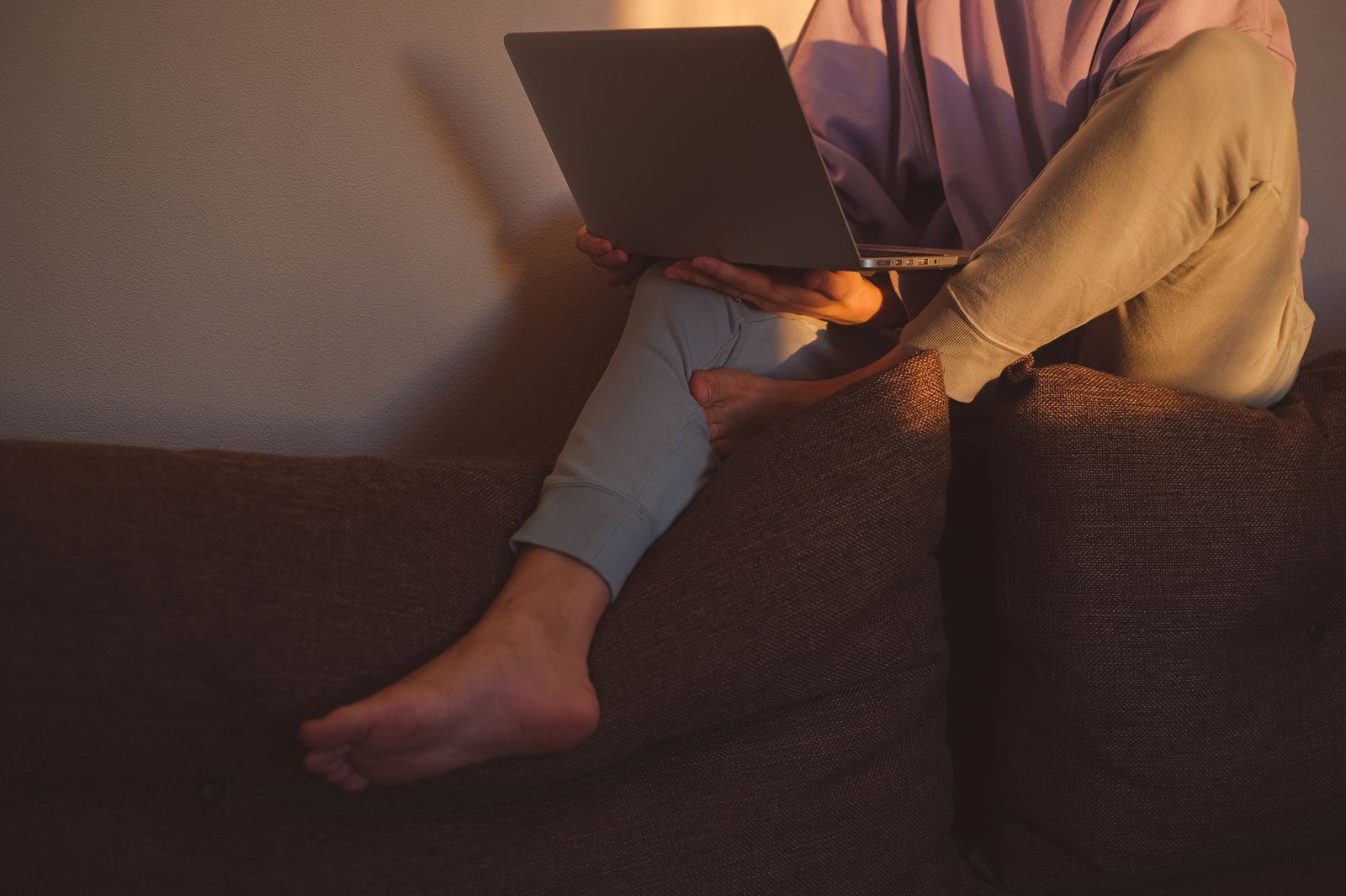 A remote worker closing a laptop as evening light enters the room.