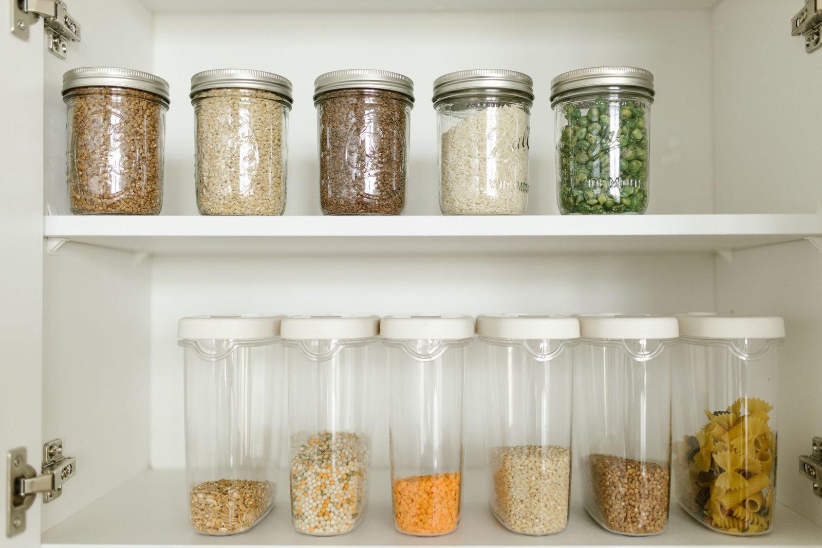 Neat rows of plastic storage bins inside a kitchen pantry cabinet.