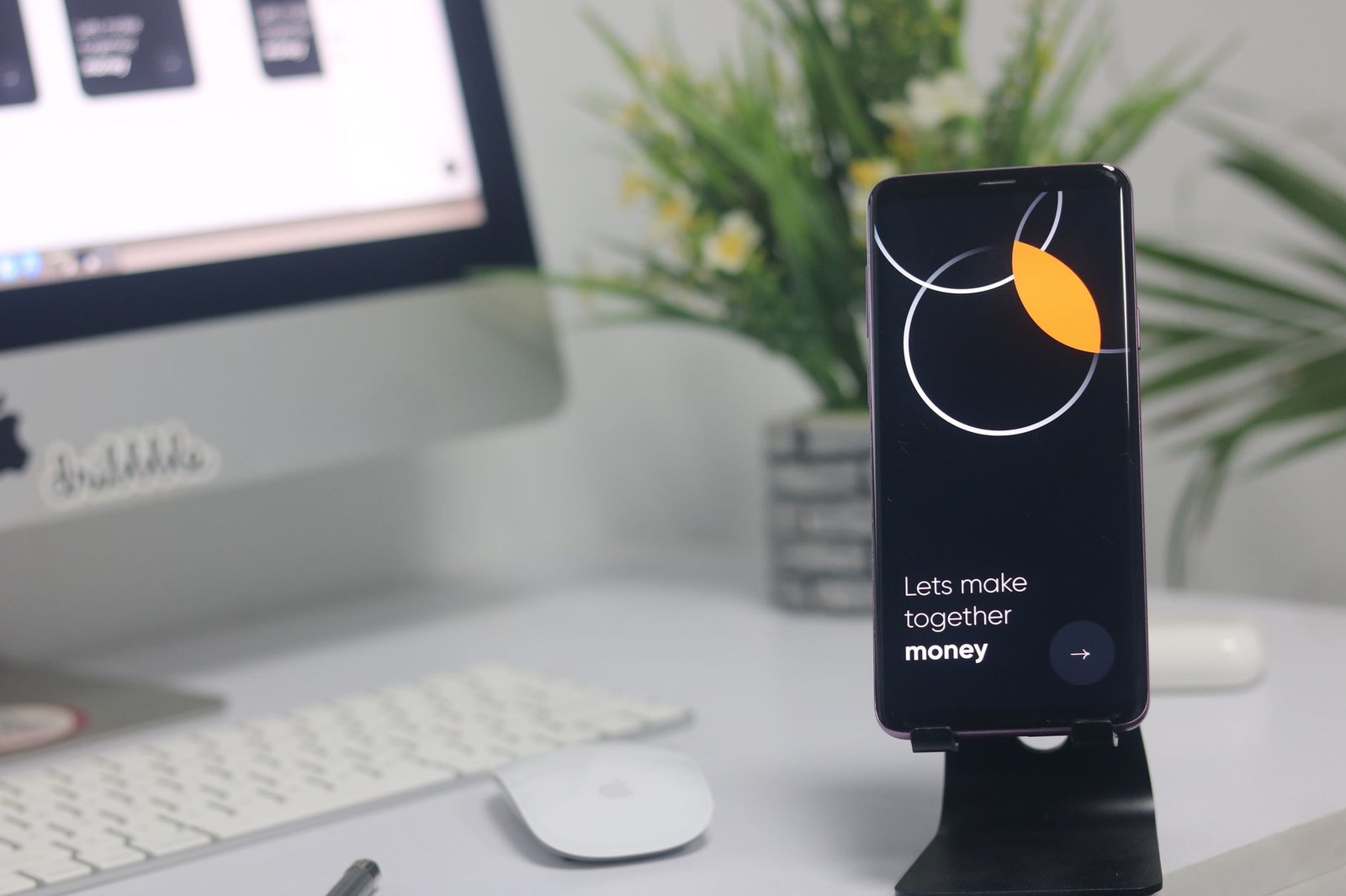 A clean minimalist desk setup with a smartphone displaying productivity widgets.