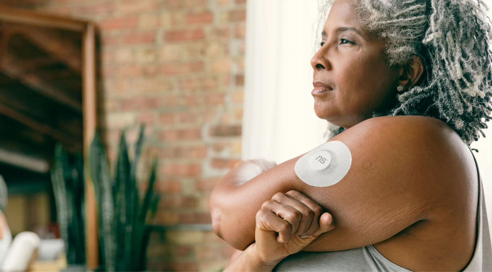 A modern continuous glucose monitor attached to a person arm.
