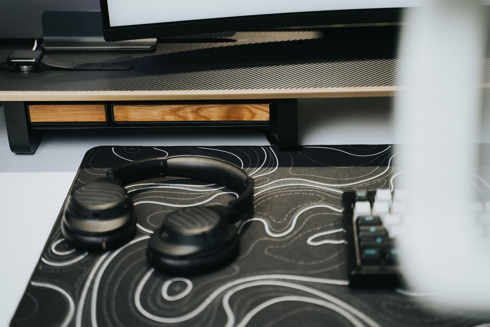 Clean wooden desk with warm monitor lighting and tidy keyboard setup.