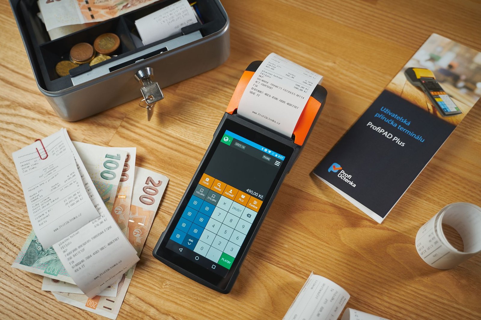 A smartphone scanning a paper receipt on a wooden desk surface.