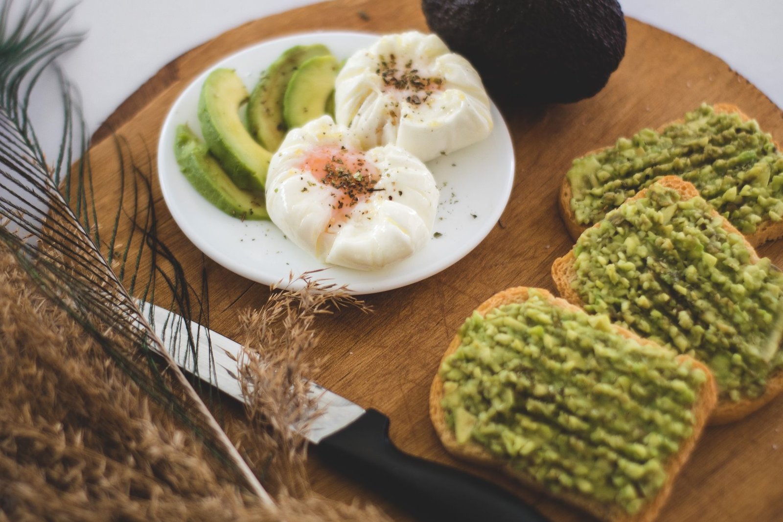 A plate of scrambled eggs and avocado slices.