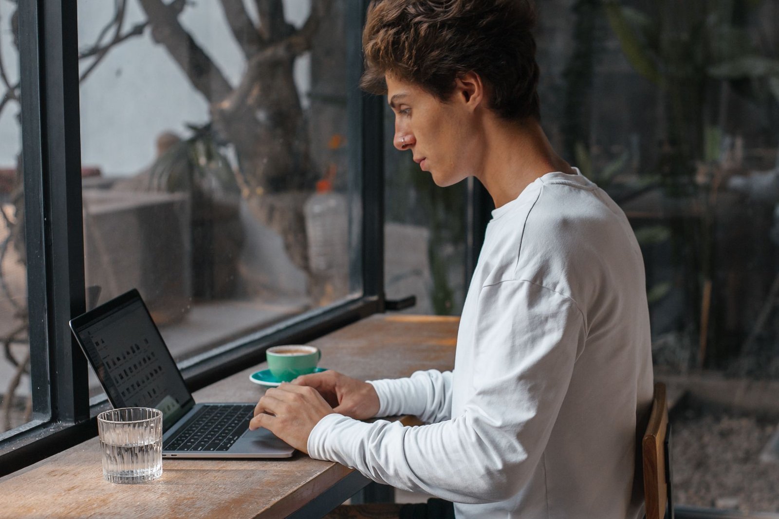 Professional focused deeply on laptop screen during a morning work block.