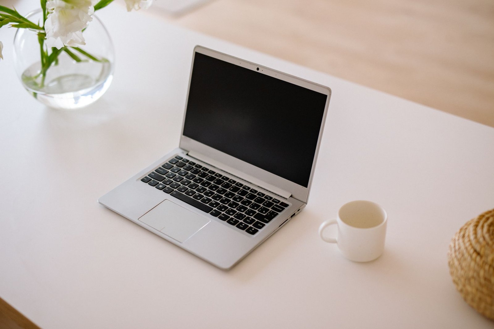 Clean wooden desk with laptop and a cup of coffee.