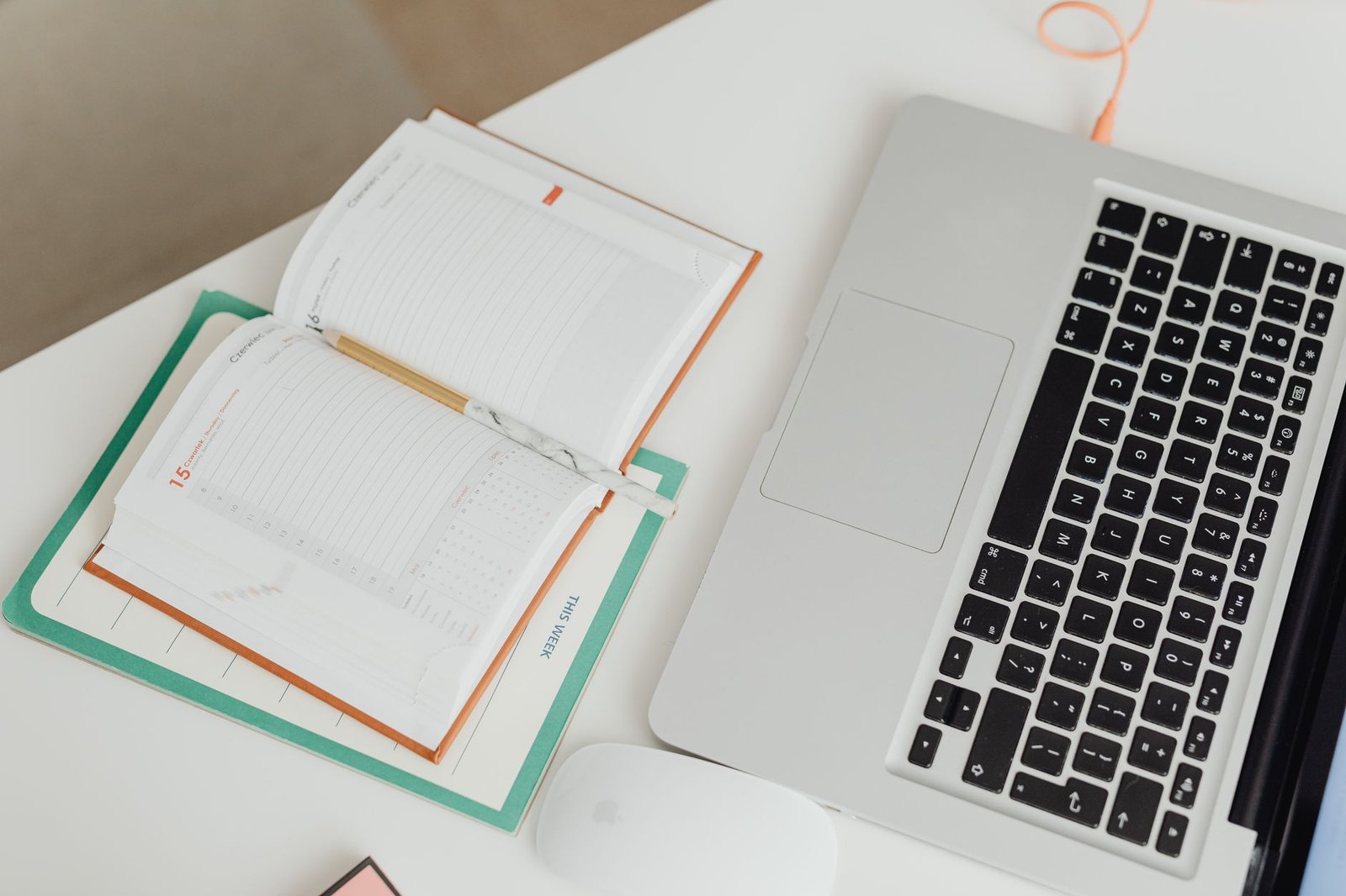 Clean modern workspace featuring a laptop and organized physical planner.