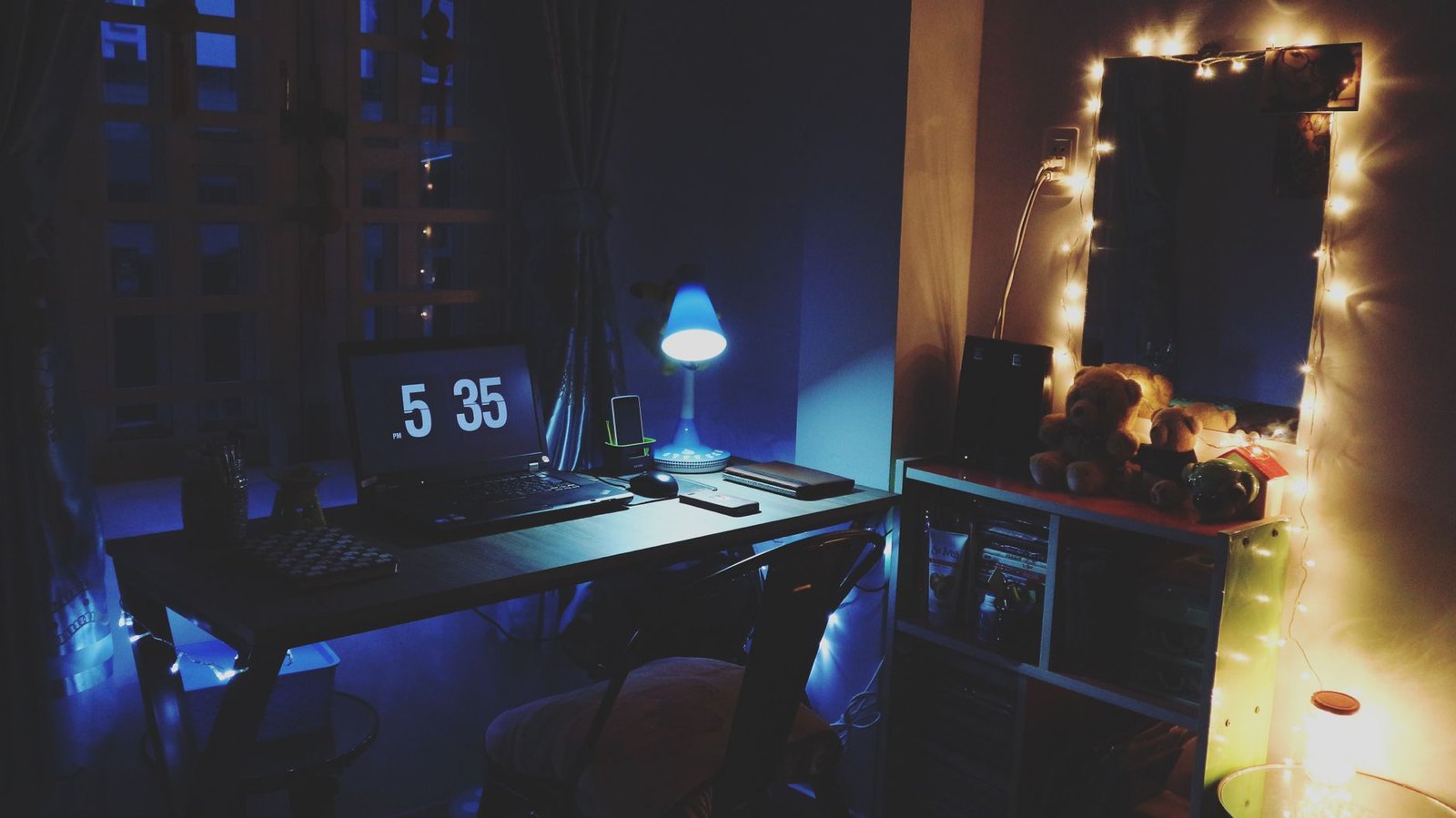 A tidy home office desk with ambient lighting at dusk.