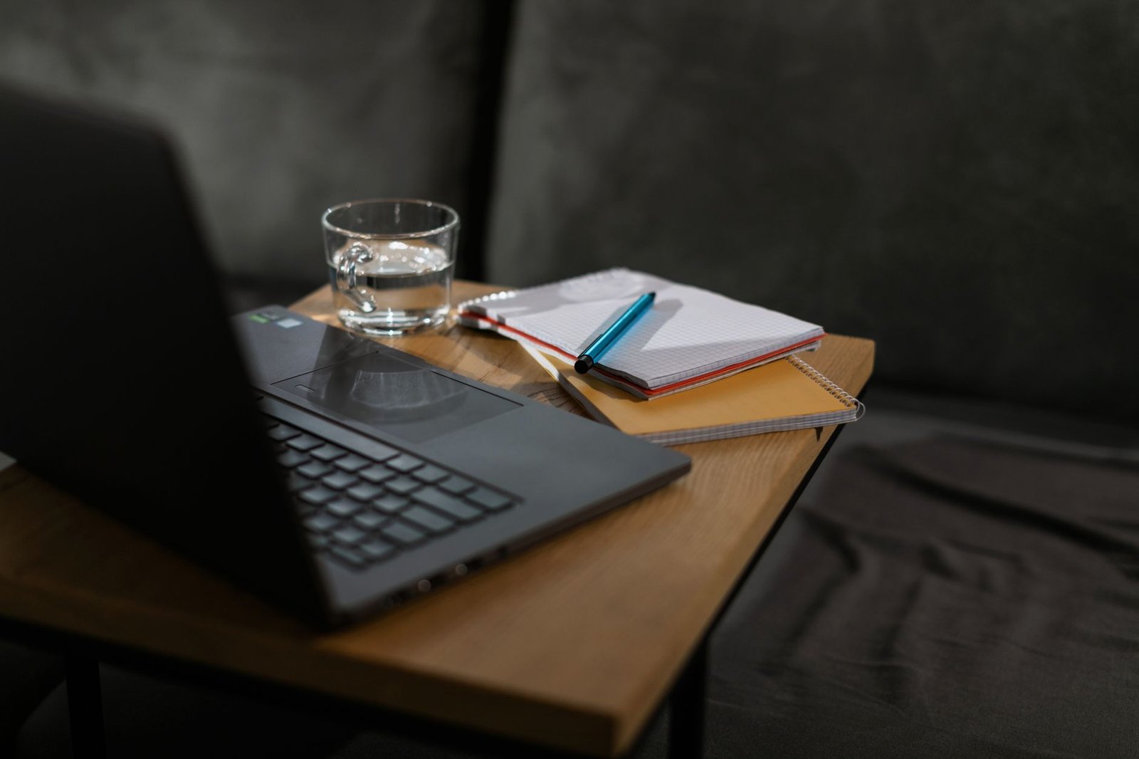 A clean modern desk with a laptop and organized notebooks.
